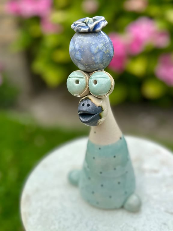 Kæmpe fugl med kugle og blomst