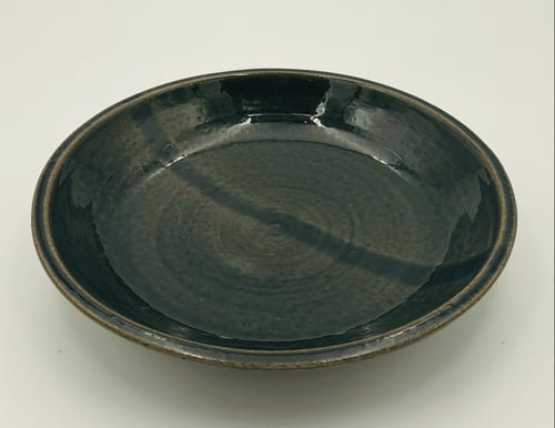 Sort, rund keramisk skål med glaseret finish, placeret på hvid overflade. (1)