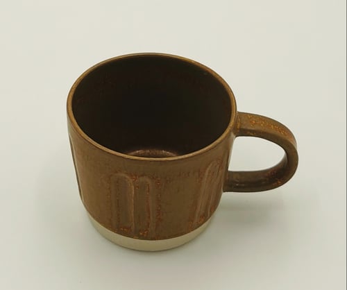 Brun keramisk kaffekop med hank på hvid baggrund. (1)
