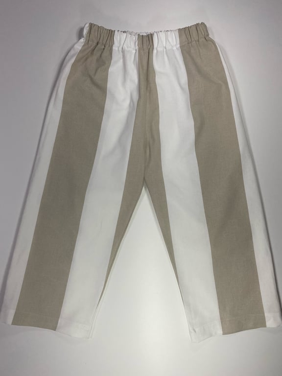 Bukser med brede lodrette striber i beige og hvid samt elastisk talje, lagt fladt på en lys overflade.