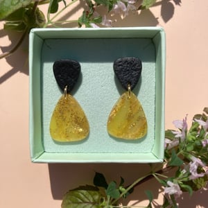 gylden sol med sort ørestik  – produktbillede