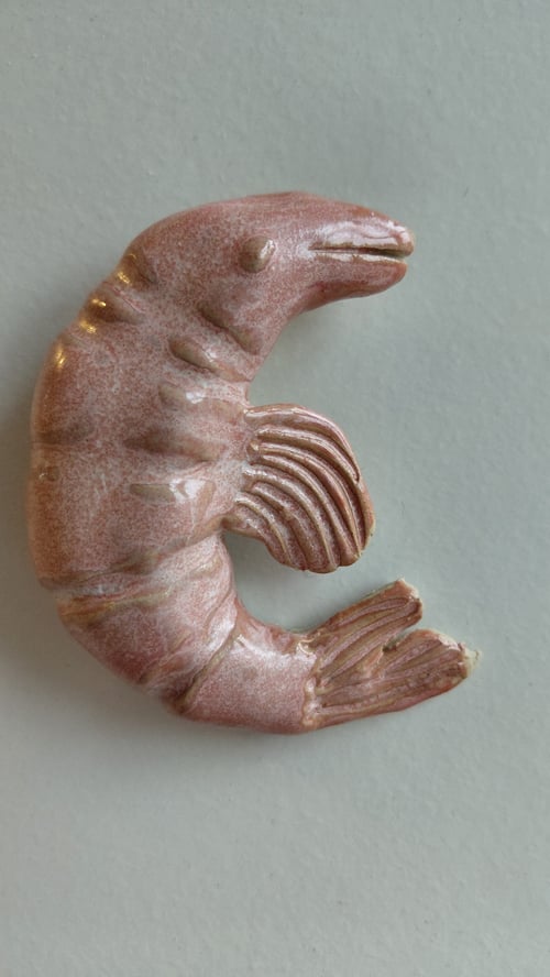Keramisk skulptur af en rejer i rosa nuance på grå baggrund. (1)