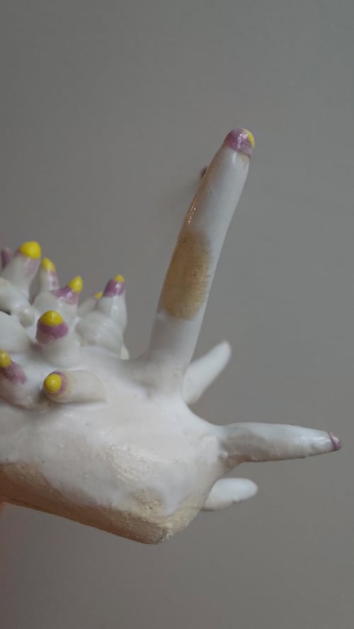Porcelænshånd med udstående fingre med lilla spidser og gule prikker. (9)