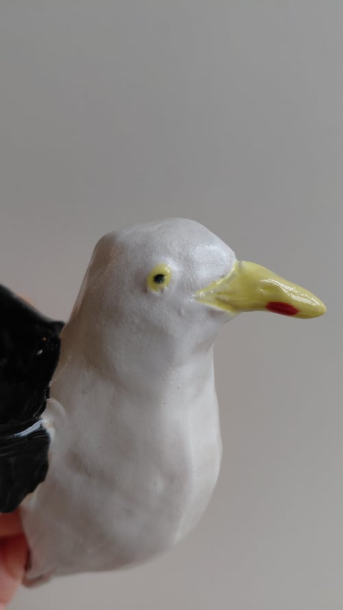 Porcelænfigur af en måge med gul næb og sort-hvide vinger. (5)