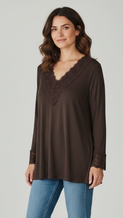 Kvinde iført brun bluse med V-udskæring og blondekanter, parret med blå jeans, stående mod neutral baggrund.
