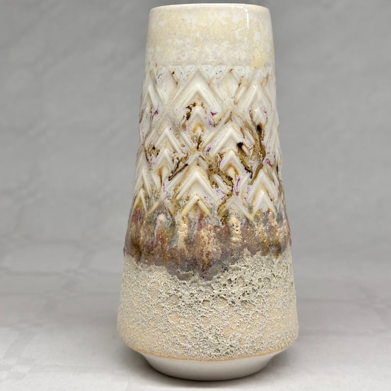 Keramisk vase med tekstureret overflade i beige, brun og lilla nuancer.
