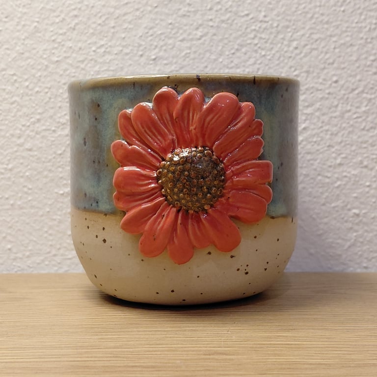 Kop med rød blomst