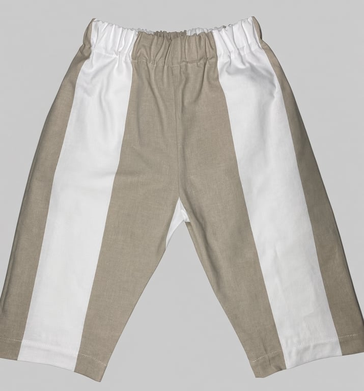 Børnebukser med brede lodrette striber i beige og hvid, elastisk talje.