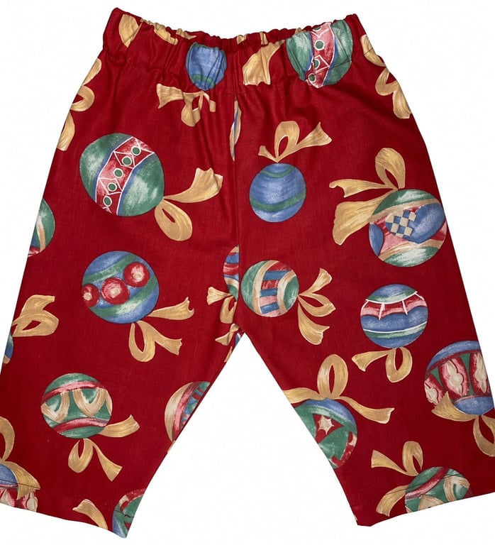 Røde shorts med elastik i taljen og mønster af farverige julekugler med gule sløjfer.