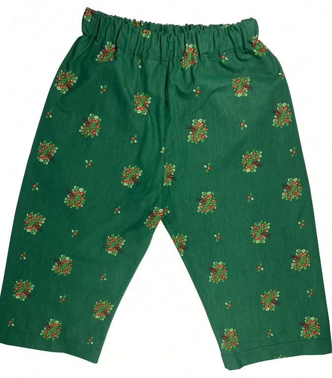 Grønne bukser med elastisk talje og små blomsterprint i røde og grønne farver spredt over stoffet.