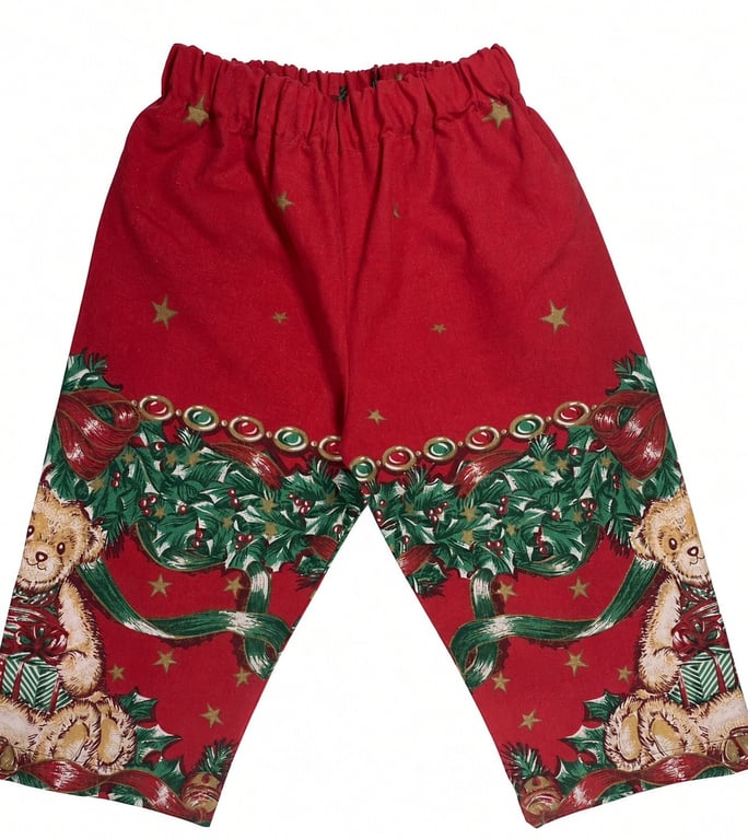 Røde bukser med julemotiv, herunder bamser, grønne grene, røde sløjfer og guldstjerner.