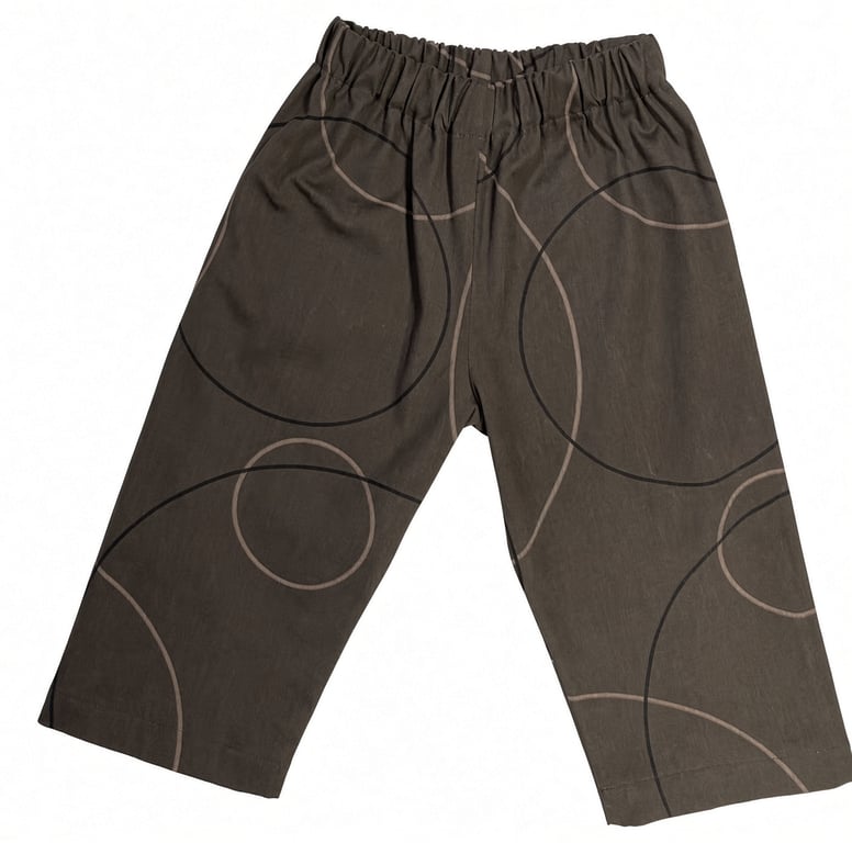 Bukser i mørkebrun farve med elastisk talje og sort og beige cirkelmønster.