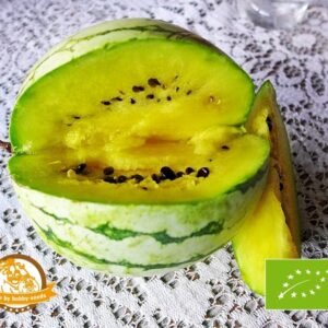 Halveret vandmelon med gul frugtkød og sorte kerner, placeret på en hvid blondeagtig borddug.