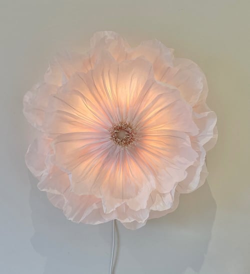Blød, lysende væglampe formet som en stor, gennemsigtig blomst med flere lag blomsterblade i lyserød nuance. (1)