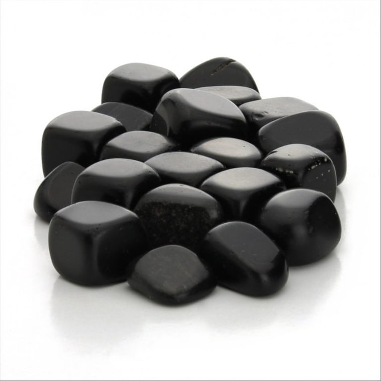 Glatte, sorte polerede sten samlet på en hvid overflade. (2)