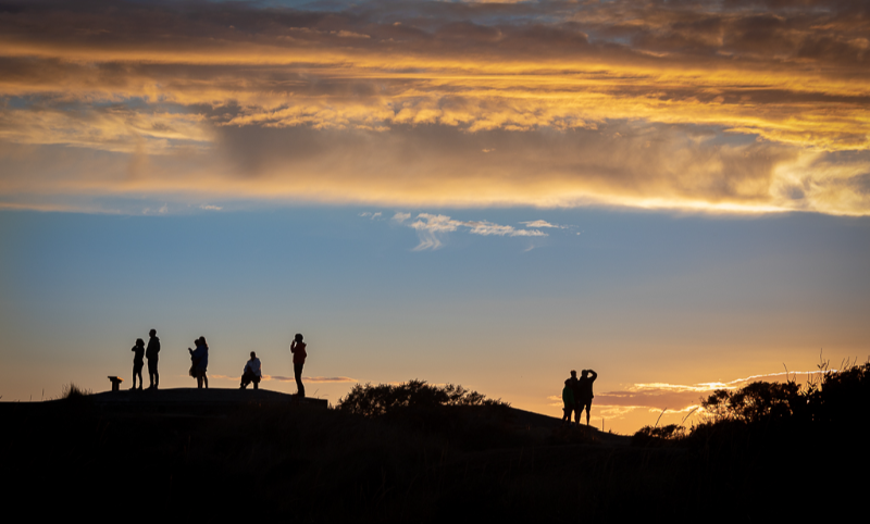 Silhuetter mod solnedgangen på Grenen i Skagen en smuk sommeraften