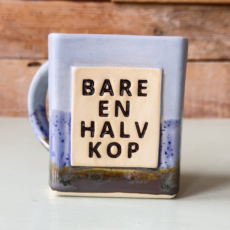 Kaffekop med teksten "Bare en halv kop" på dansk.