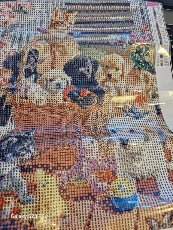Billede af en diamantmaleri-kunst med flere forskellige hunde og katte, hvor maleriet består af små firkanter med bogstaver og tal som guide til farvelægning.
