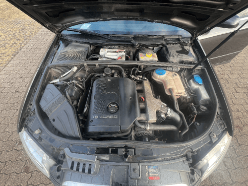Bilens motor med motorhjelmen åben, hvor en 1.8 turbo-motor og omkringliggende komponenter ses tydeligt. (3)