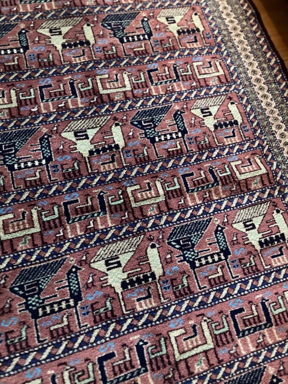 Tæppe med geometriske mønstre og dyrefigurer i nuancer af rød, blå, sort og hvid. (2)