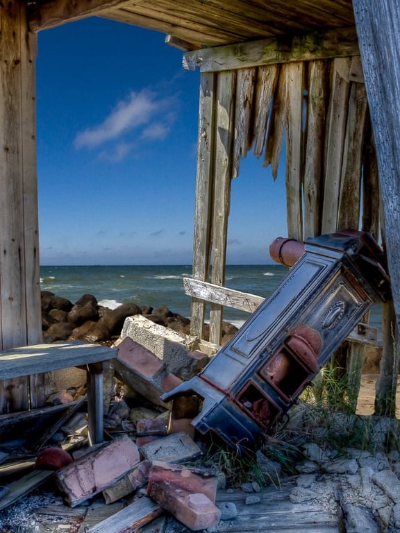 En forfalden fiskerhytte med udsigt til vandet på Ulvshale på Møn