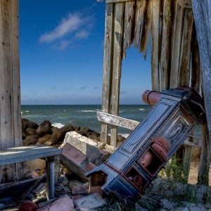 En forfalden fiskerhytte med udsigt til vandet på Ulvshale på Møn – produktbillede