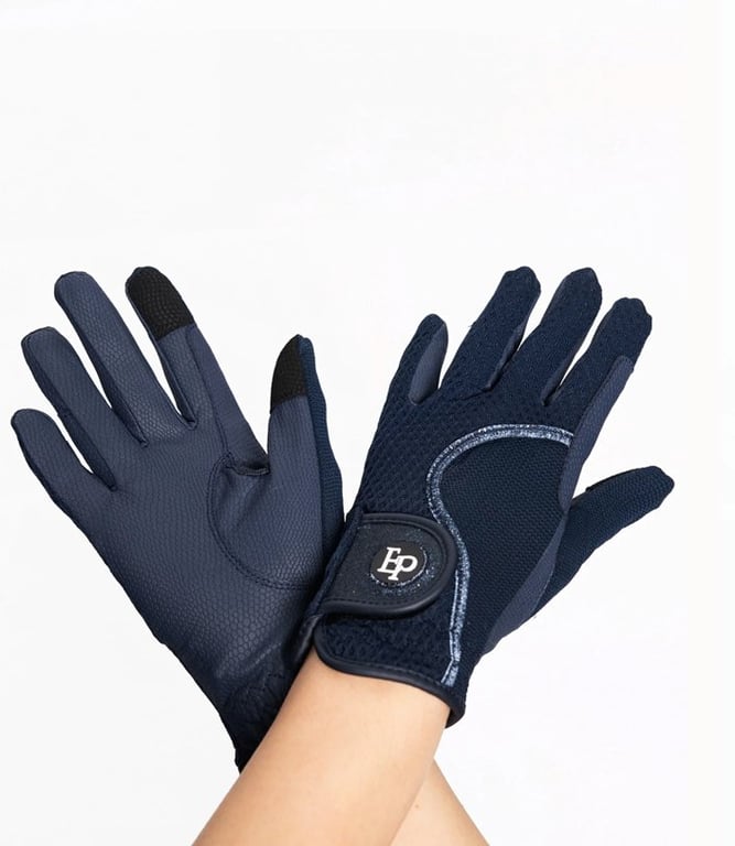 Par mørkeblå ridhandsker med velcro-lukning, båret på to hænder mod en hvid baggrund.