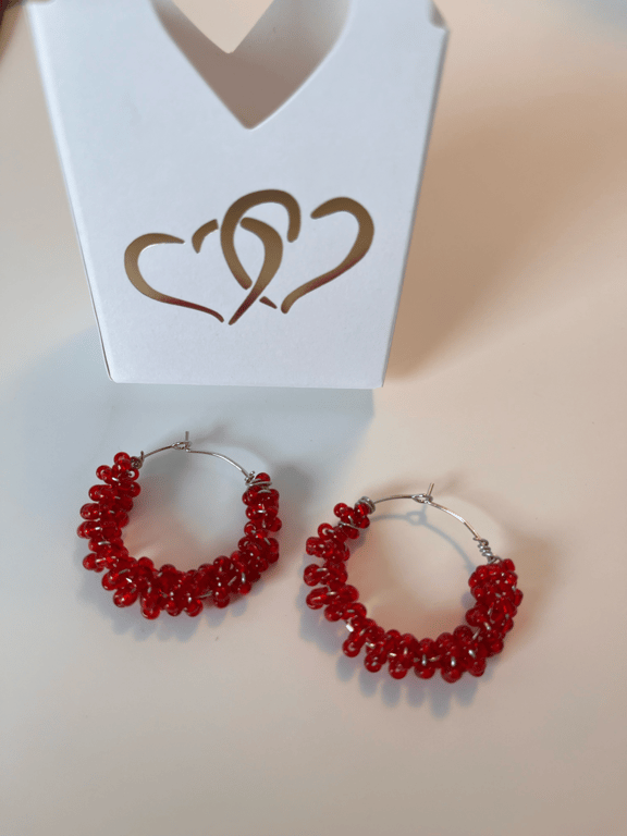 Mørke rødeperler snoet omkring creolerne