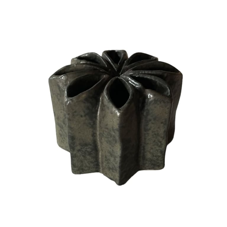 Keramisk, stjernelignende vase med åbninger på toppen, mørkegrå og blank overflade.