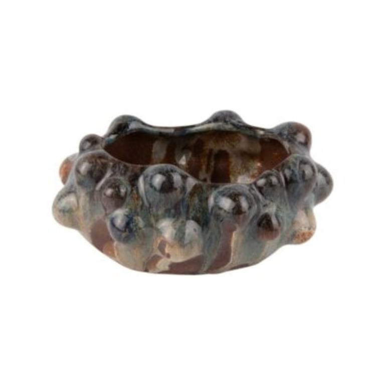 Keramisk skål med uregelmæssig, boblet overflade og glasur i mørke nuancer.