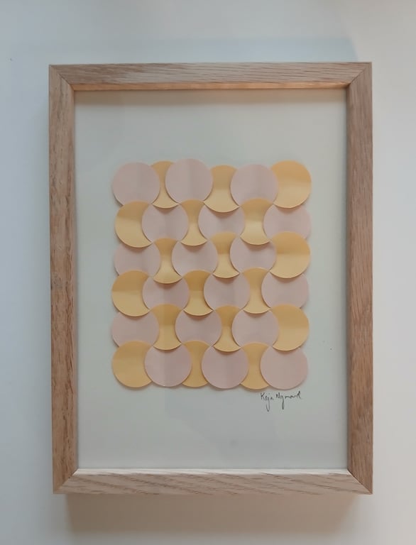 Billedramme med et geometrisk mønster bestående af skiftevis beige og gule cirkler, hvor dele af cirklerne er bukket op for at skabe et tredimensionelt udtryk.