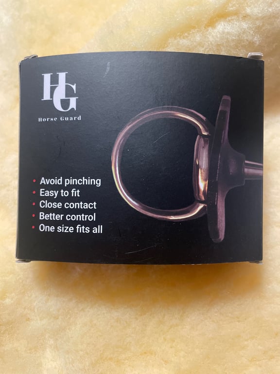 Sort emballage med tekst og billede af bid til hest, mærket "Horse Guard" med funktioner som undgå klemning, let at montere, tæt kontakt, bedre kontrol og én størrelse passer alle.