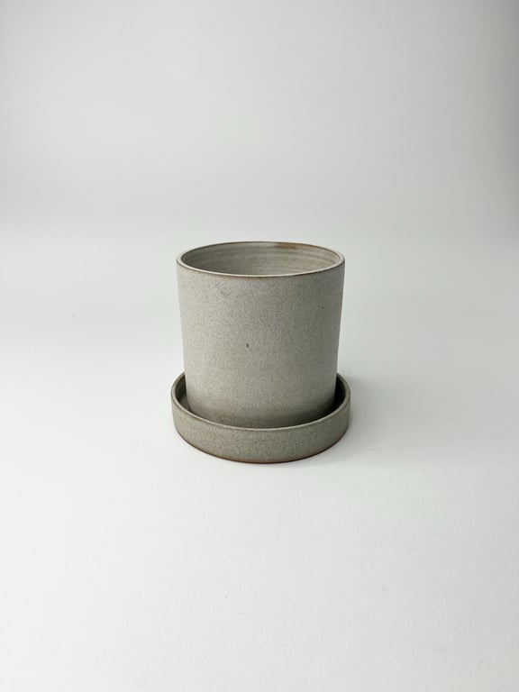 Grå keramik plantepotte med underskål på hvid baggrund.