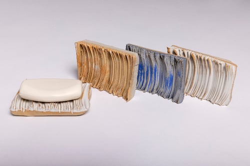 Billedet viser fire knuste maltede kiks med lag af smør på, arrangeret i en linje mod højre, mod en hvid baggrund.