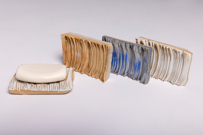 Billedet viser fire knuste maltede kiks med lag af smør på, arrangeret i en linje mod højre, mod en hvid baggrund.