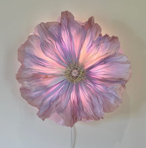 Stor, lysende lampe formet som en detaljeret pink og lilla blomst, der hænger på en væg. (1)