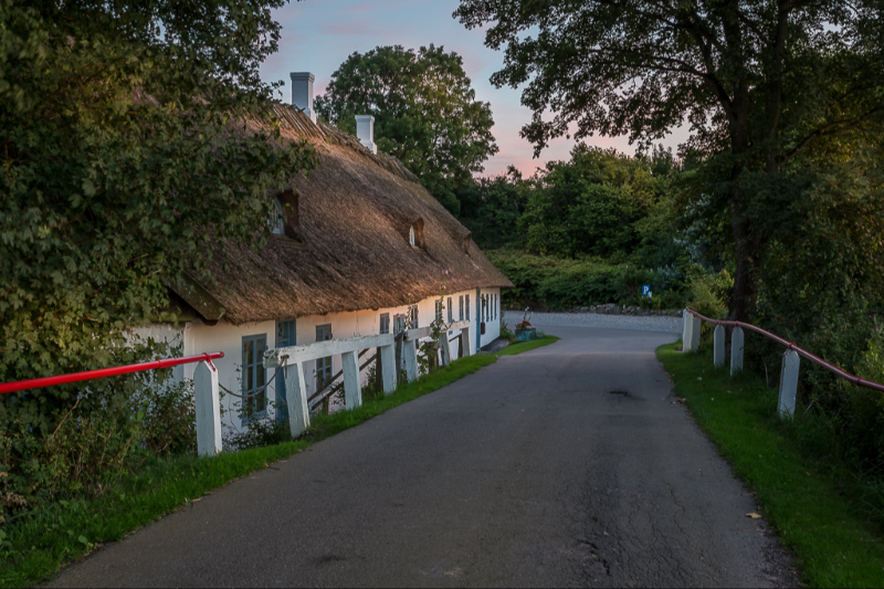 Solnedgang over det smukke stråtækte hus ved Blåbæk mølle sø