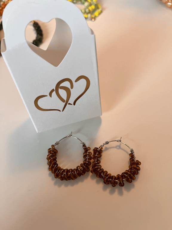 Brune glasperler snoet omkring creolerne