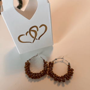 Brune glasperler snoet omkring creolerne – produktbillede