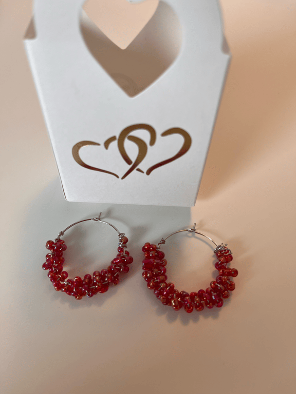 Rødefarvet perler snoet omkring creolen