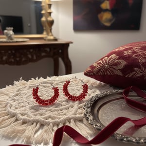 Mørke rødeperler snoet omkring creolerne – produktbillede