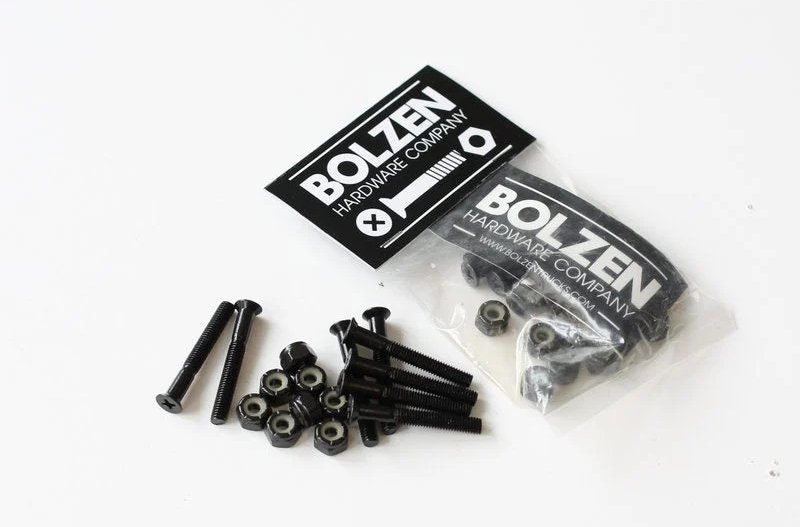 Sort hardware-sæt med skruer og møtrikker fra Bolzen Hardware Company, delvist pakket i plastikpose.