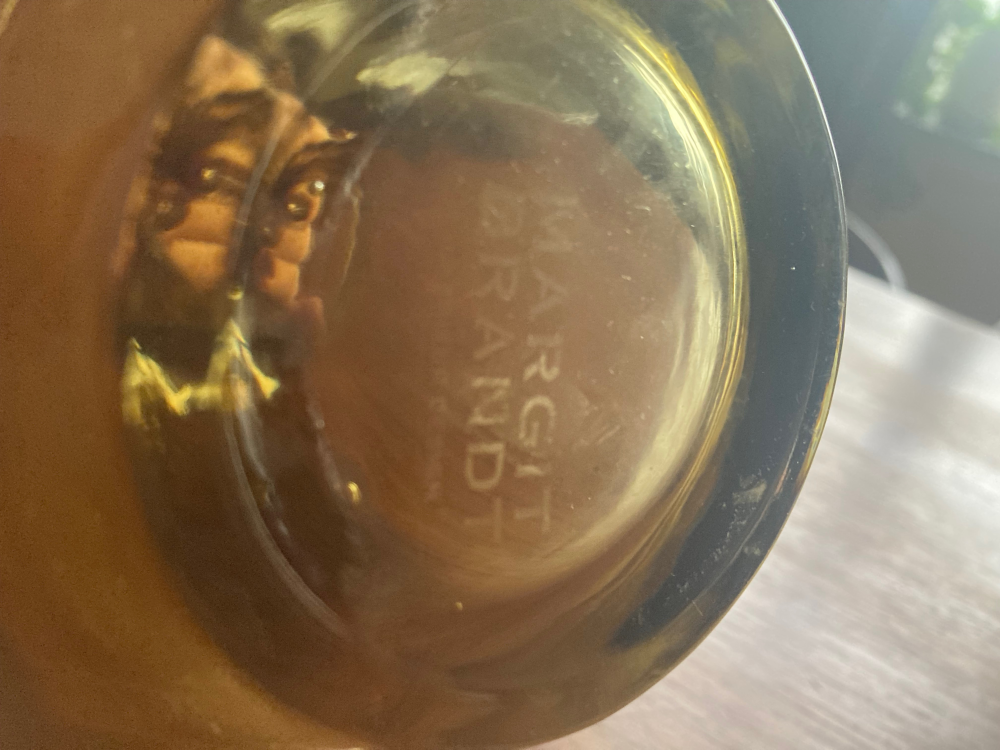 Nærbillede af en guldfarvet fløjte med mærkaten "MARGITI BRANDT" indgraveret på indersiden. (3)