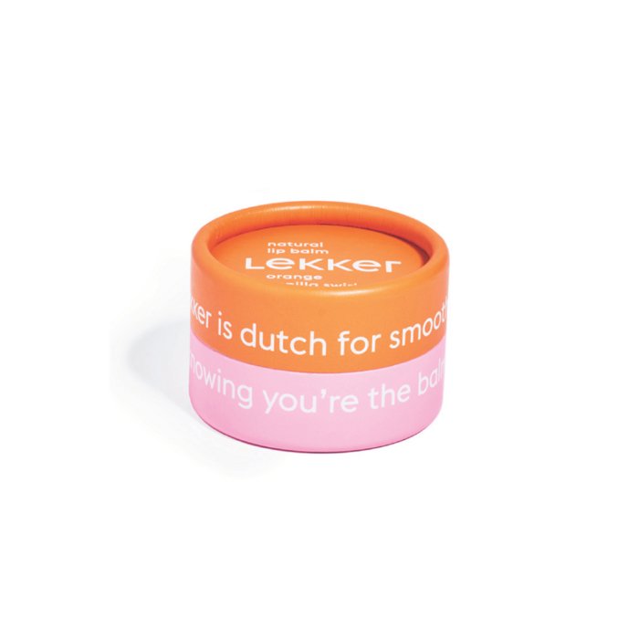 Den orange og lyserøde rundformede beholder med læbepomade mærket "Lekker" med tekst på engelsk og hollandsk.