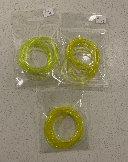 Tre små plastikposer med sammenrullede, gule plastikrør, hver pose mærket med "2 m" og "19,-". (2)