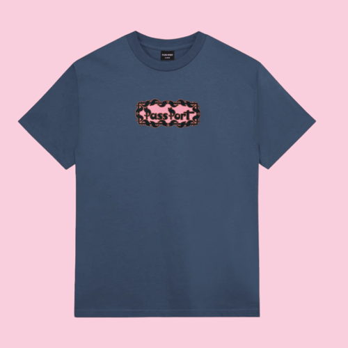 Blå T-shirt med rund hals og grafisk logo med teksten "Pass Port" på brystet, mod lyserød baggrund. (1)