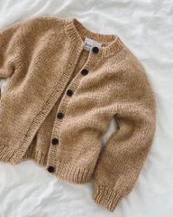 Strikket beige cardigan med sorte knapper lagt fladt på en hvid overflade. (1)