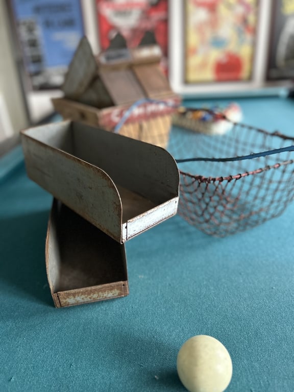 To metal skuffer, en kurv og en hvid kugle på en grøn bordflade. (2)