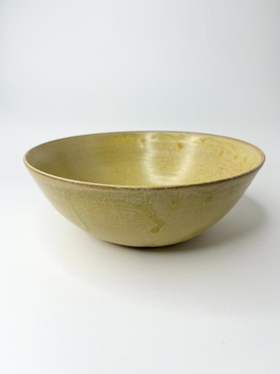 Gulgrøn keramisk skål på hvid baggrund.