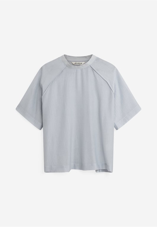 Lyseblå kortærmet bluse med rund hals og let struktur, fremstillet af let stof.